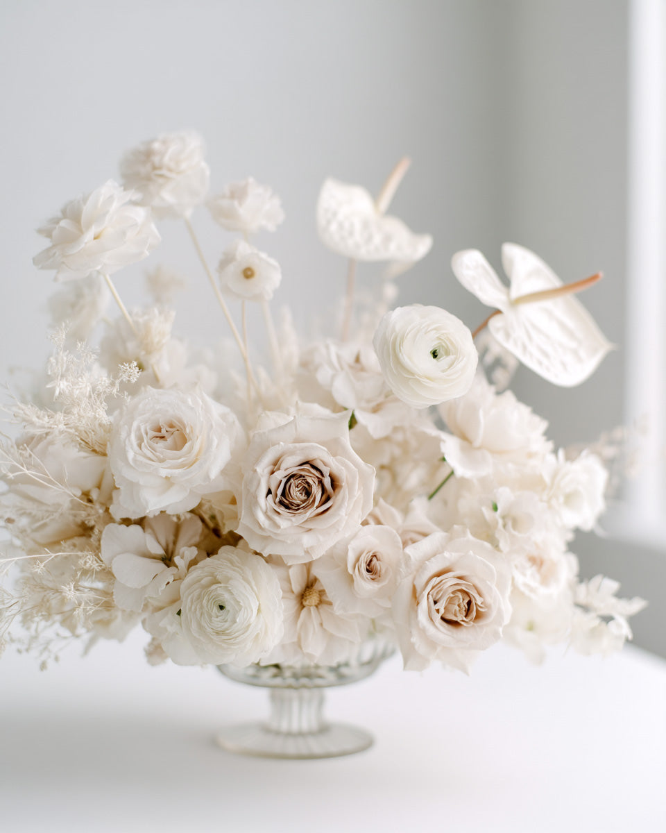 Minimalist white floral arrangement in glass vase, roses and ranunculus, luxury wedding stock photo