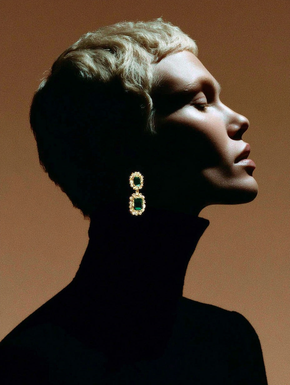 Profile portrait of woman in black turtleneck with statement emerald earrings, dramatic fashion stock photo