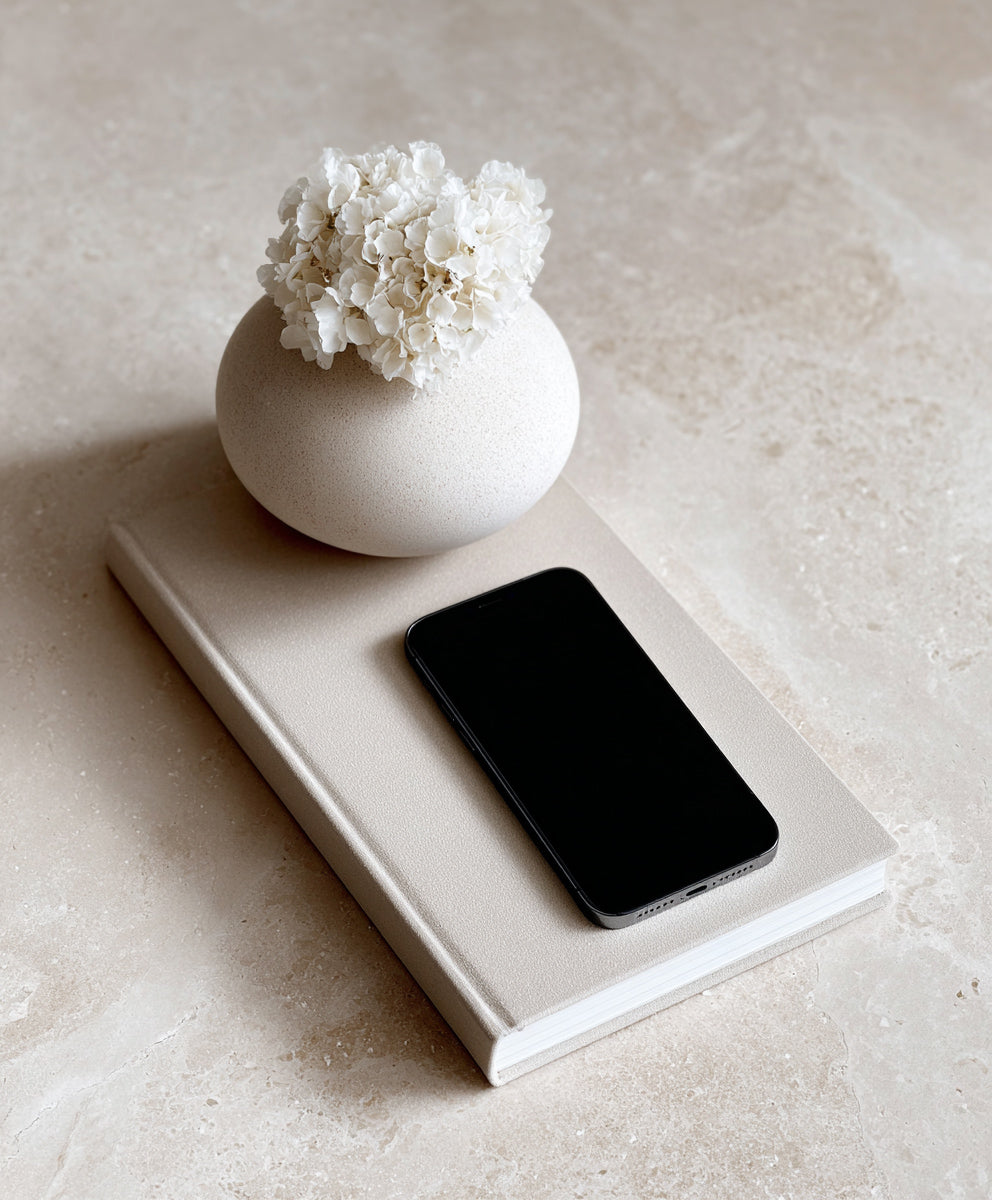 minimalist floral flatlay with iphone and notebook