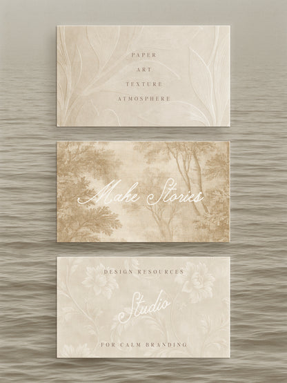 Three rectangular paper cards with a soft beige and cream botanical design are arranged vertically on a textured gray background. The top card reads 'PAPER ART TEXTURE ATMOSPHERE,' the middle reads 'Make Stories,' and the bottom reads 'DESIGN RESOURCES Studio FOR CALM BRANDING.